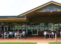 Building courtyard with rows of seating with people seated at the tables.