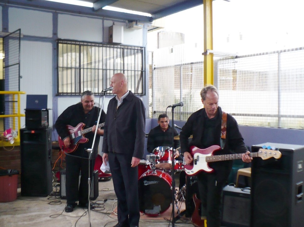 Murray Cook playing the guitar with Peter Garret and Midnight Oil 