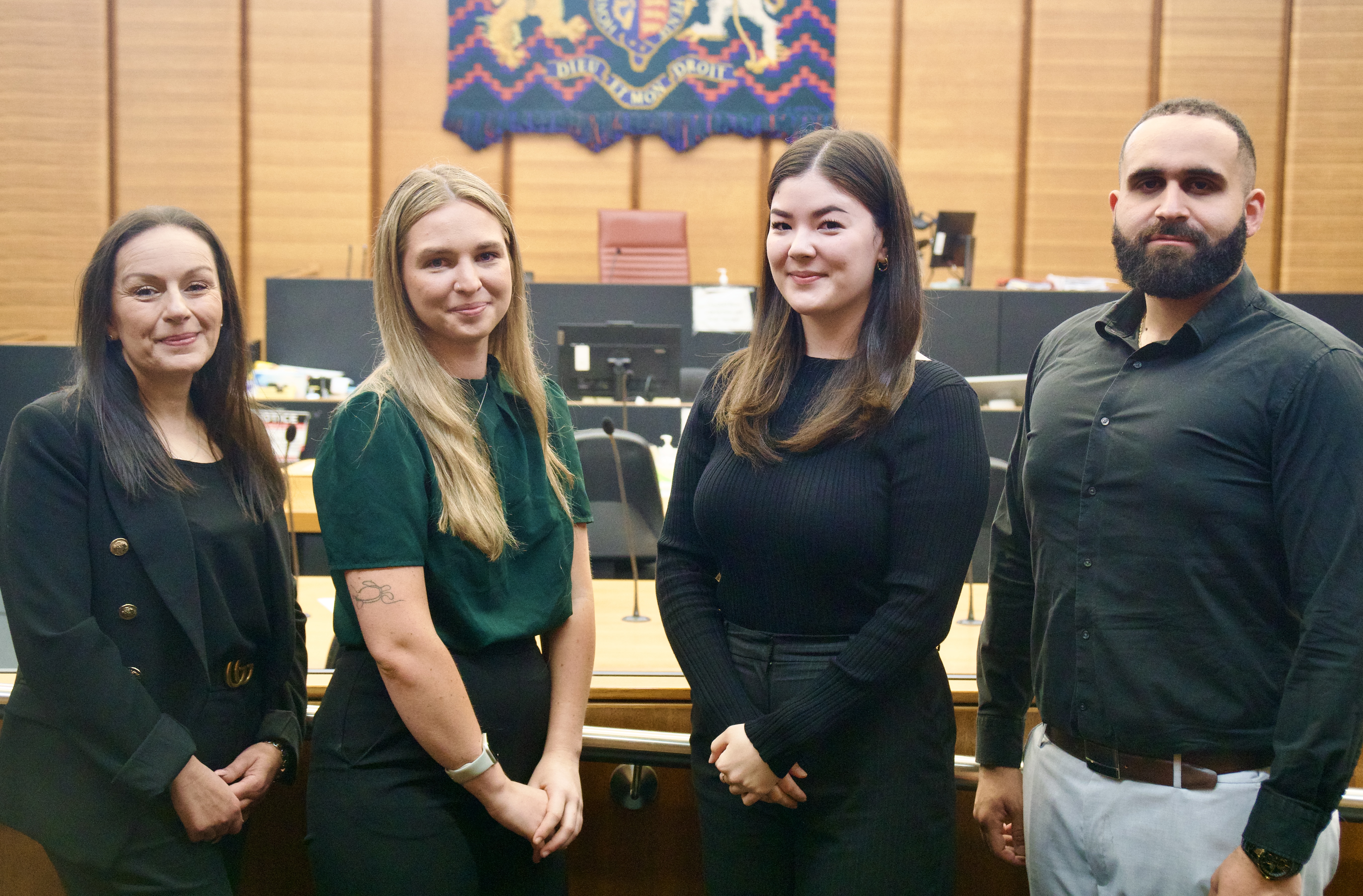 An image of four client service officers inside a courtroom