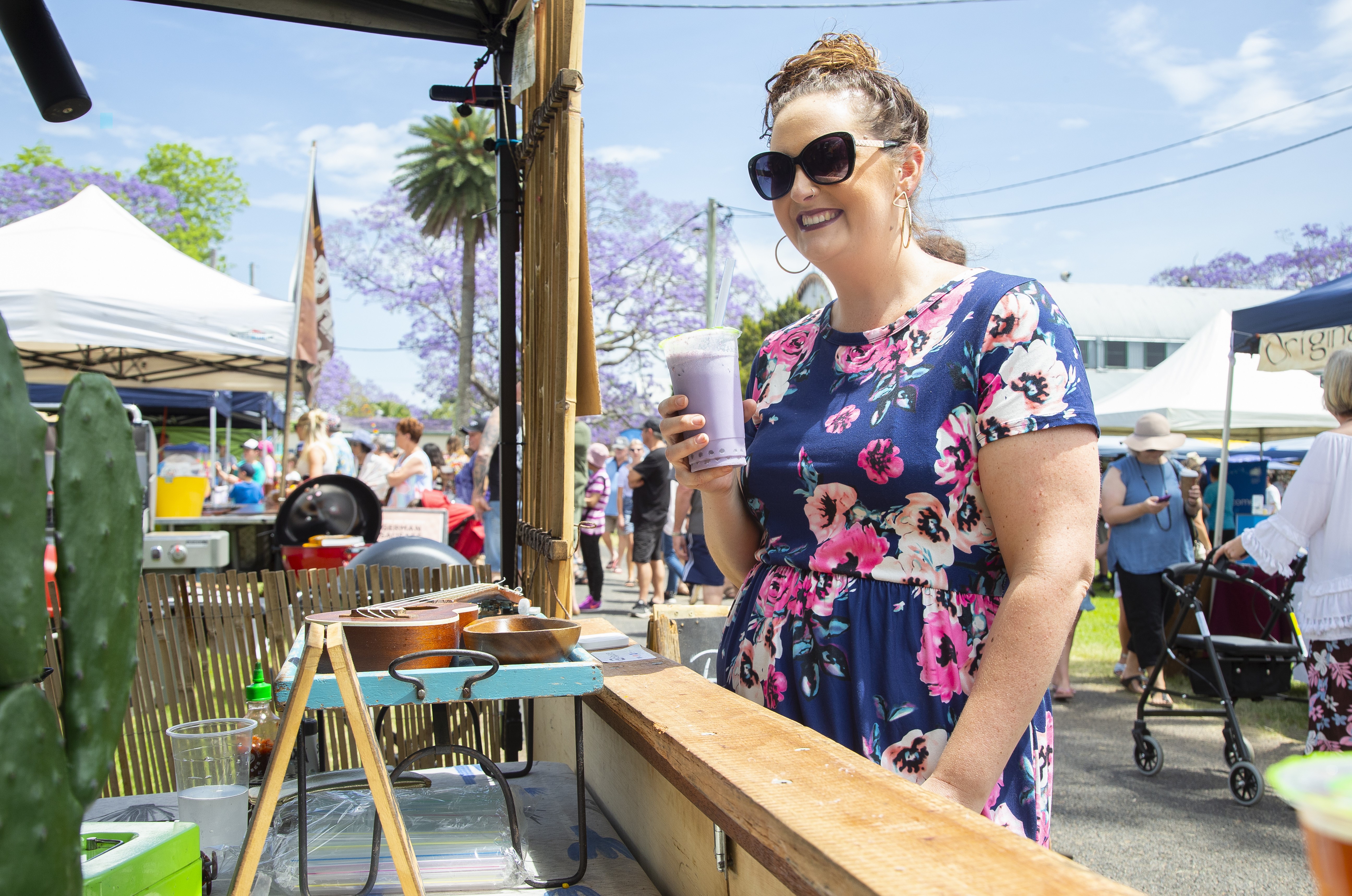 A photo of a woman drinking a beverage at the Jacaranda Festival