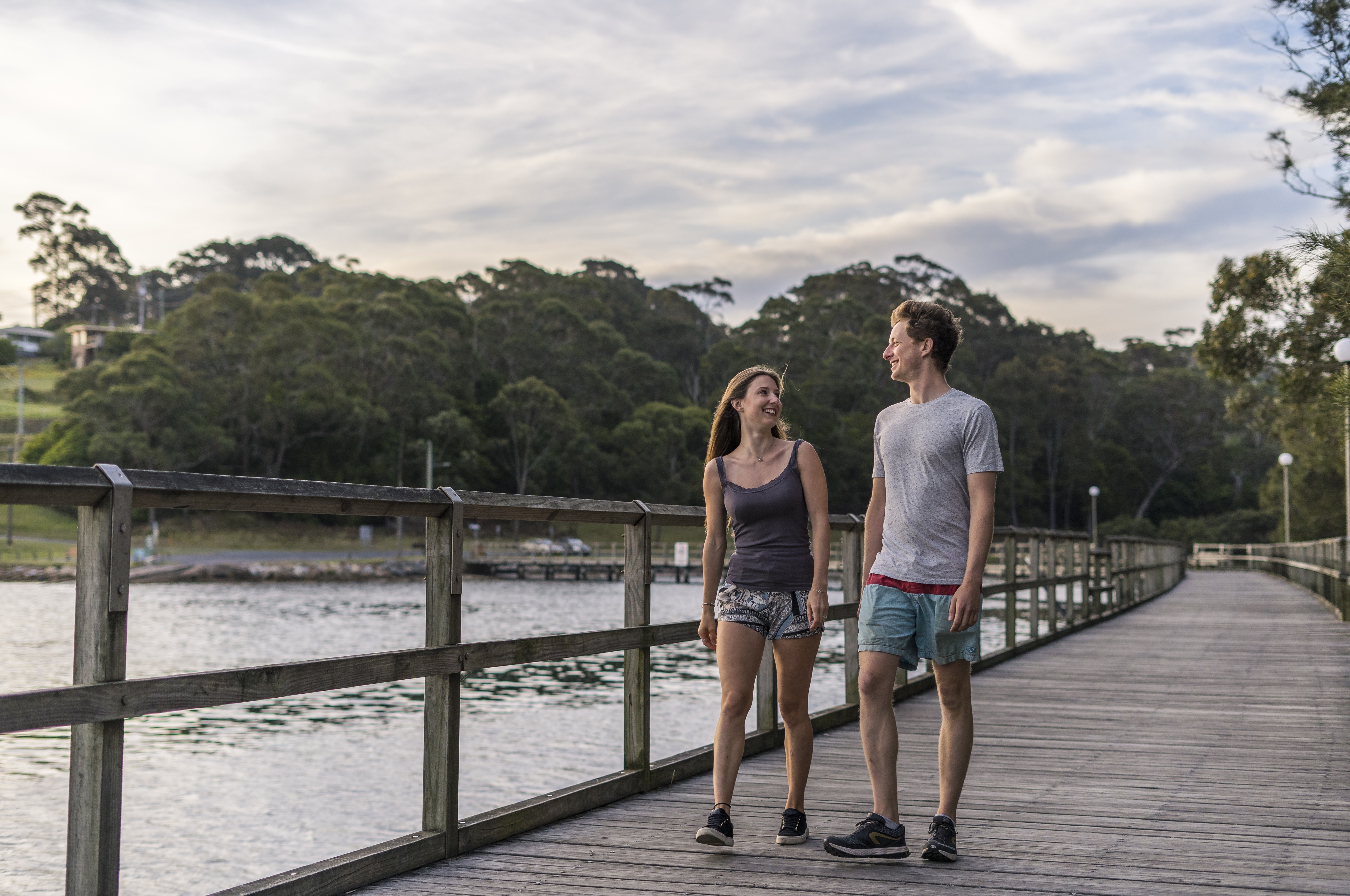 A couple walking down Mill Bay Boardwalk in Narooma