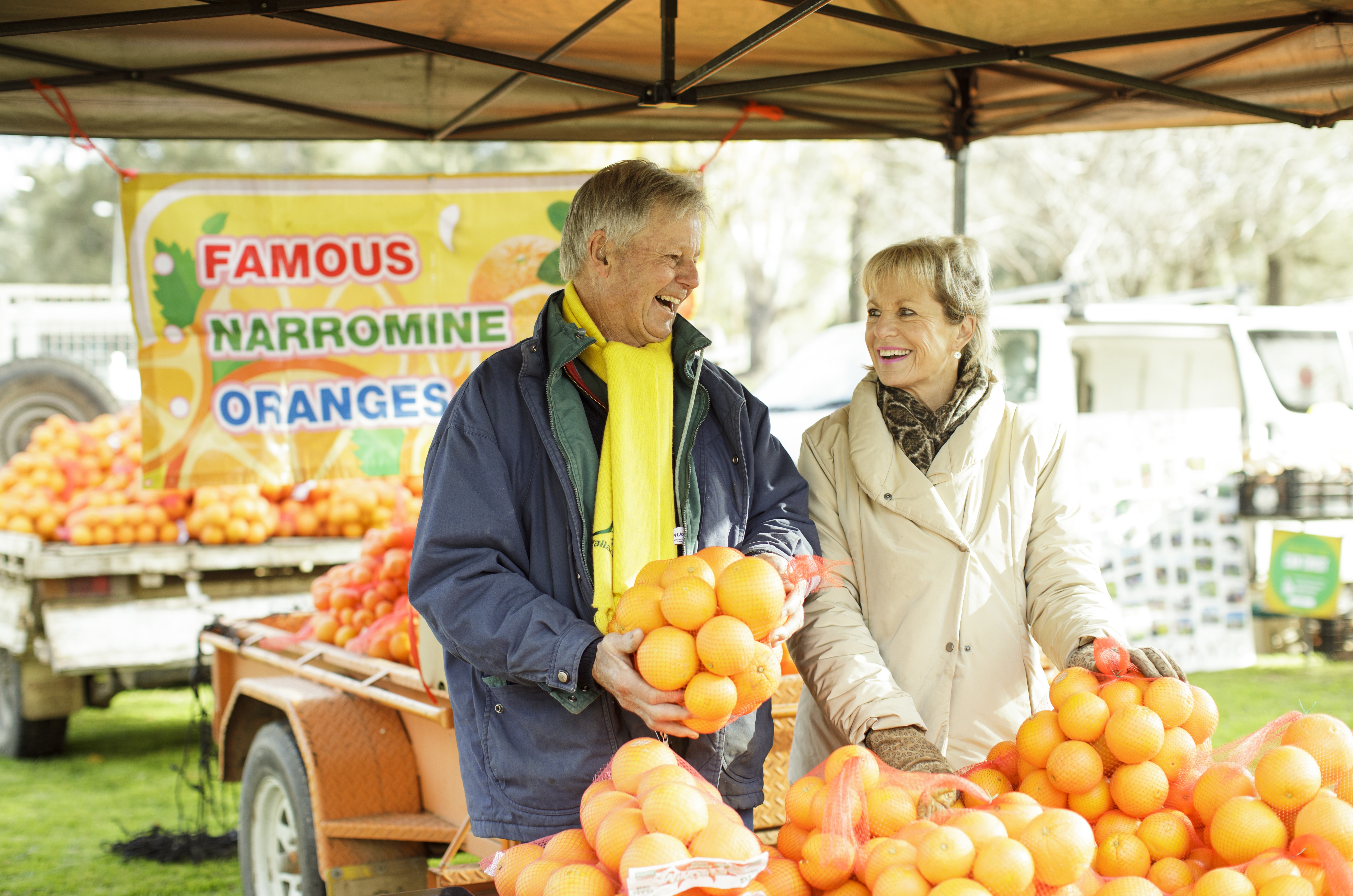 A photo of two people at an orange stand at the Dubbo Farmers Market