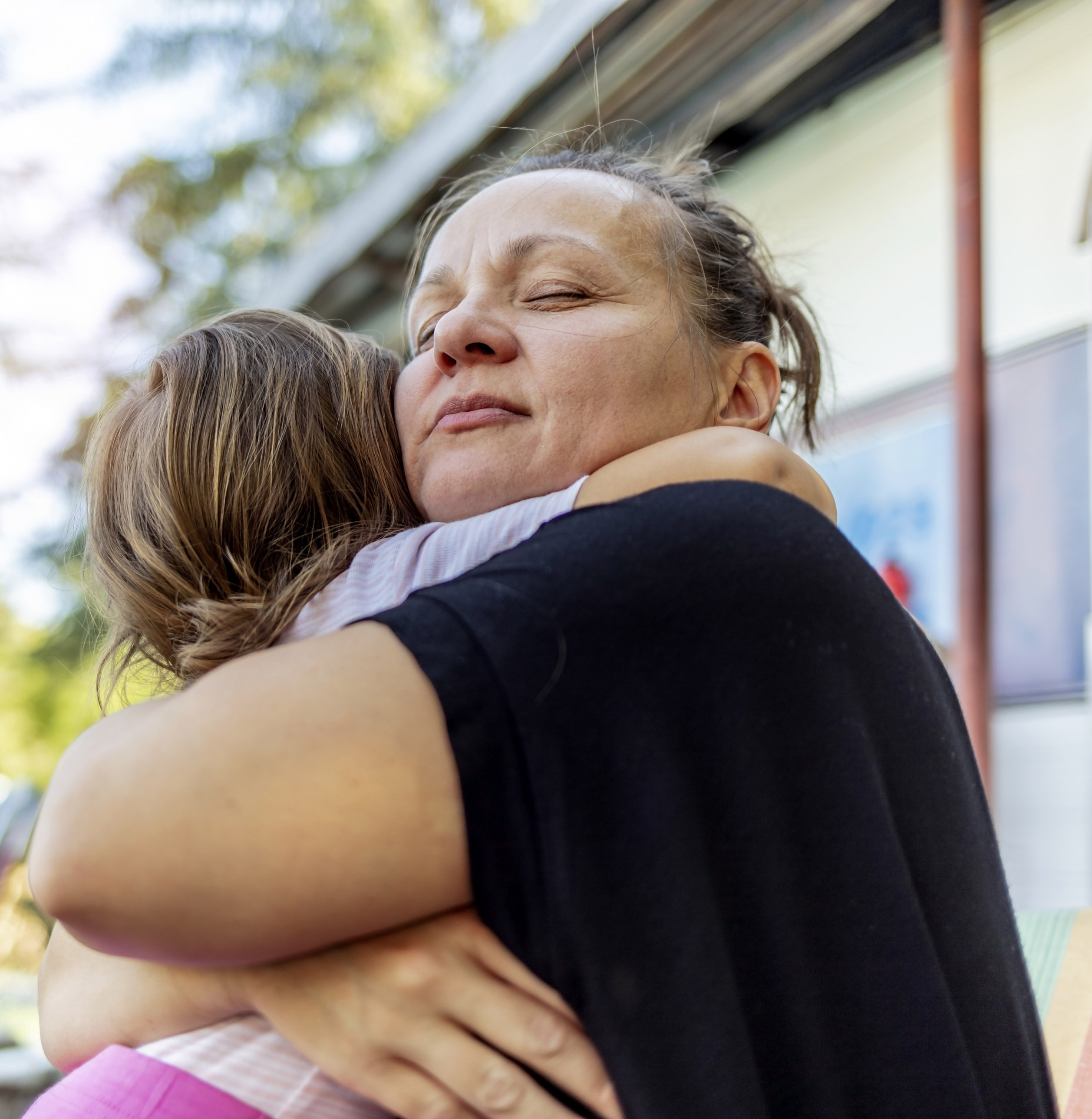 carer hugging and supporting young child