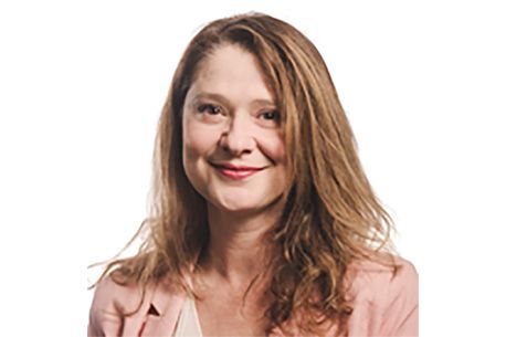 Portrait of Julianna Demetrius smiling at the camera wearing a pink cardigan
