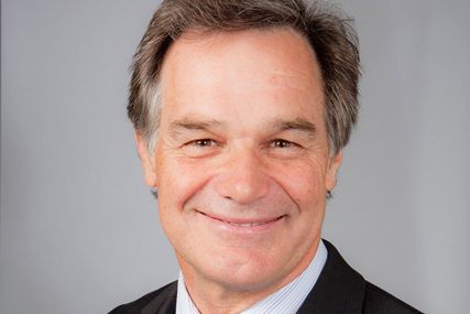 Portrait of Steve Kinmond smiling at the camera wearing a black blazer