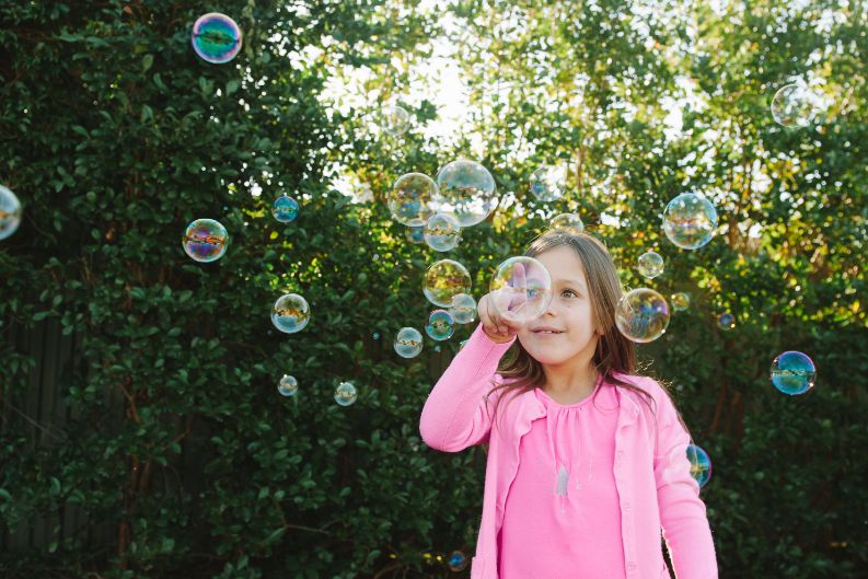 A young female popping bubbles