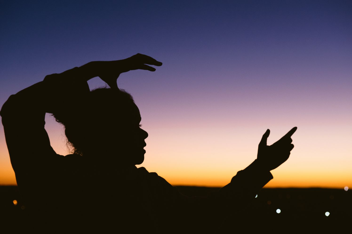 A photo of Muriel with a sunset behind her 