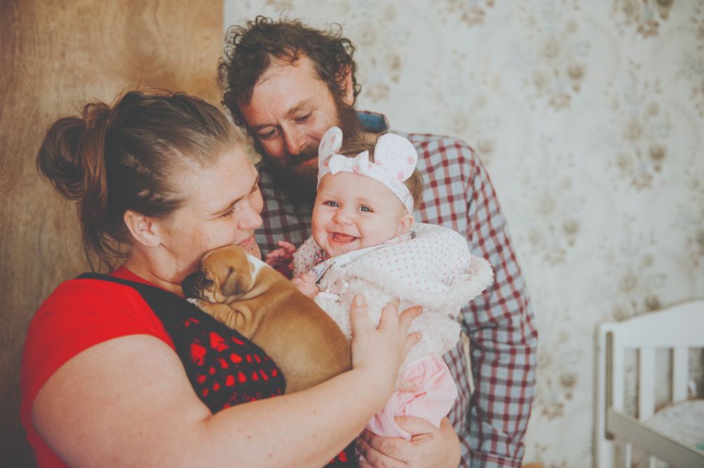 A photo of Jessica and her partner doting over their baby girl Kyesha