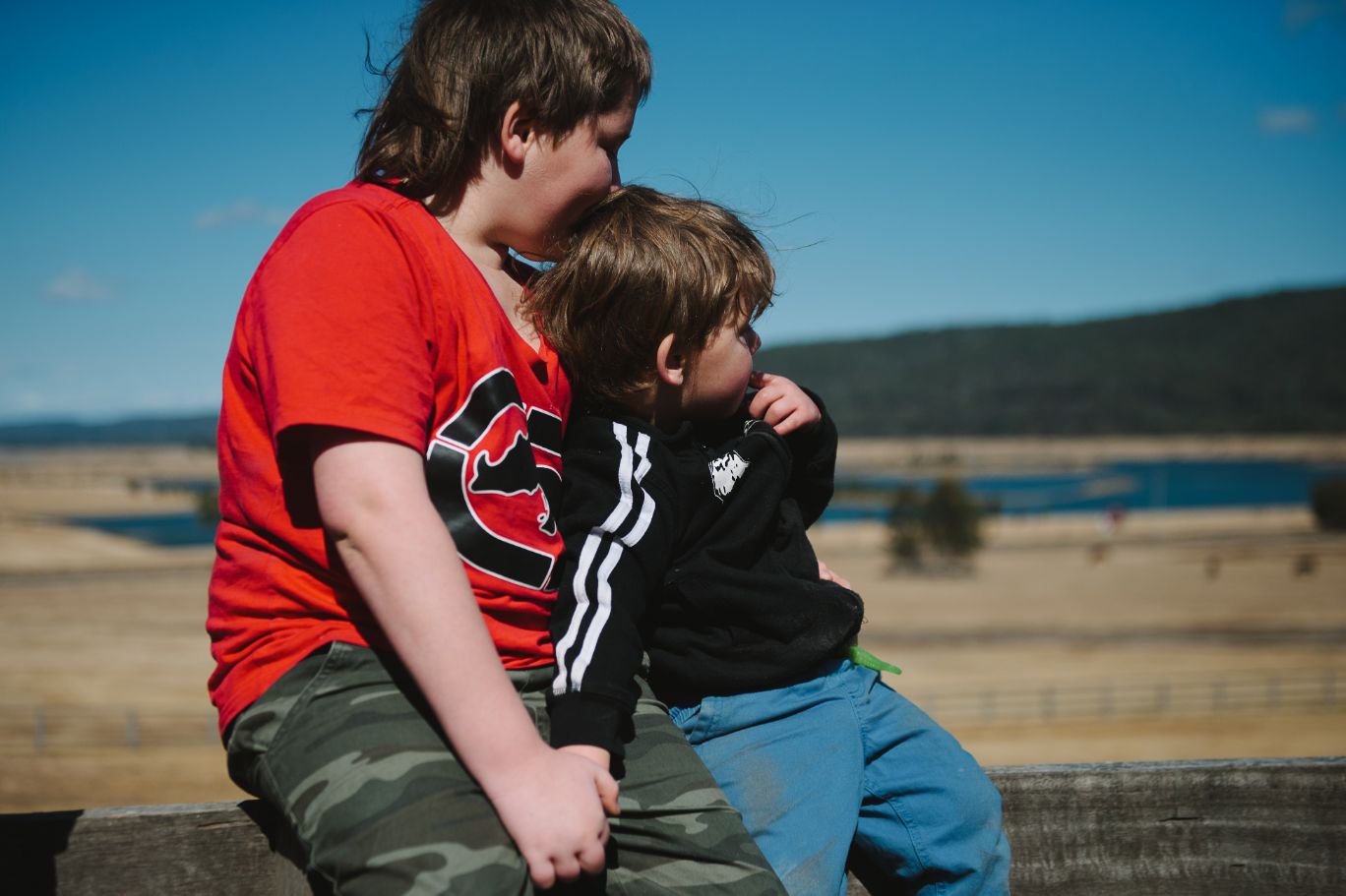 Sarah's sons sitting down together staring into the distance