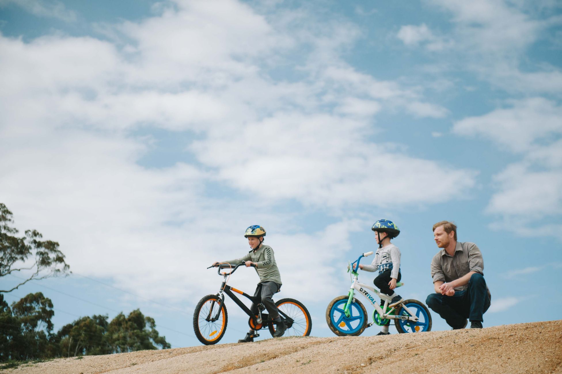 Adam with his sons who are both on pushbikes