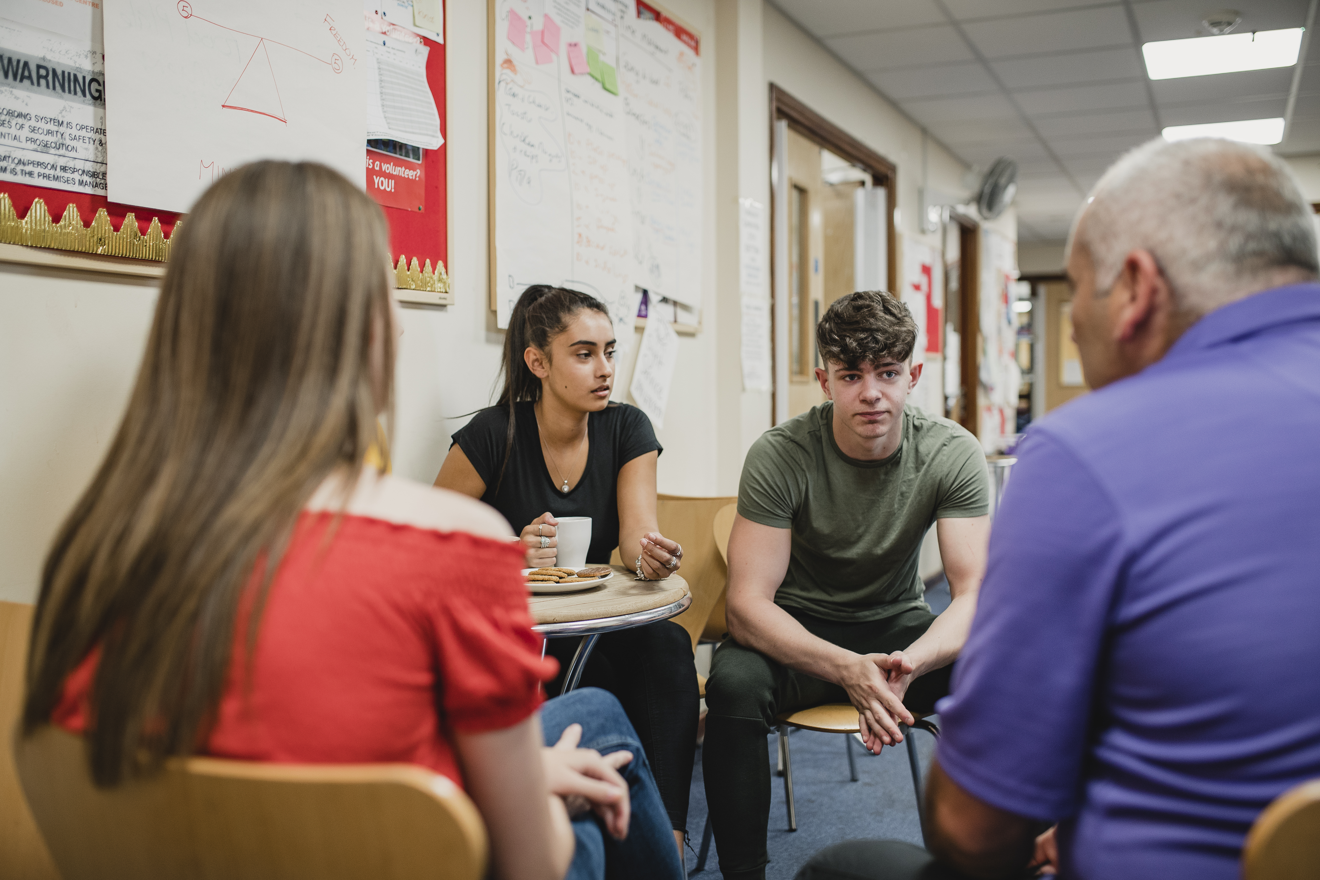 Teenagers seated at group therapy at a community centre.